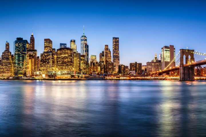 a bridge over a body of water with a city in the background