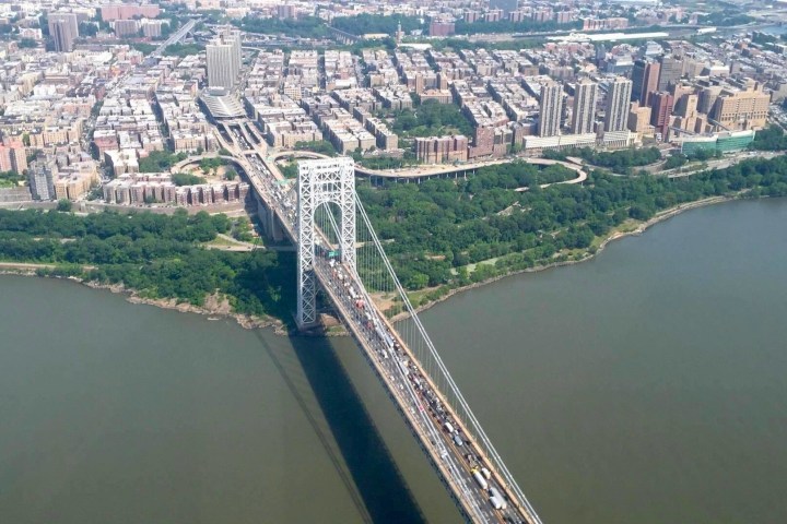 a bridge over a body of water with a city in the background